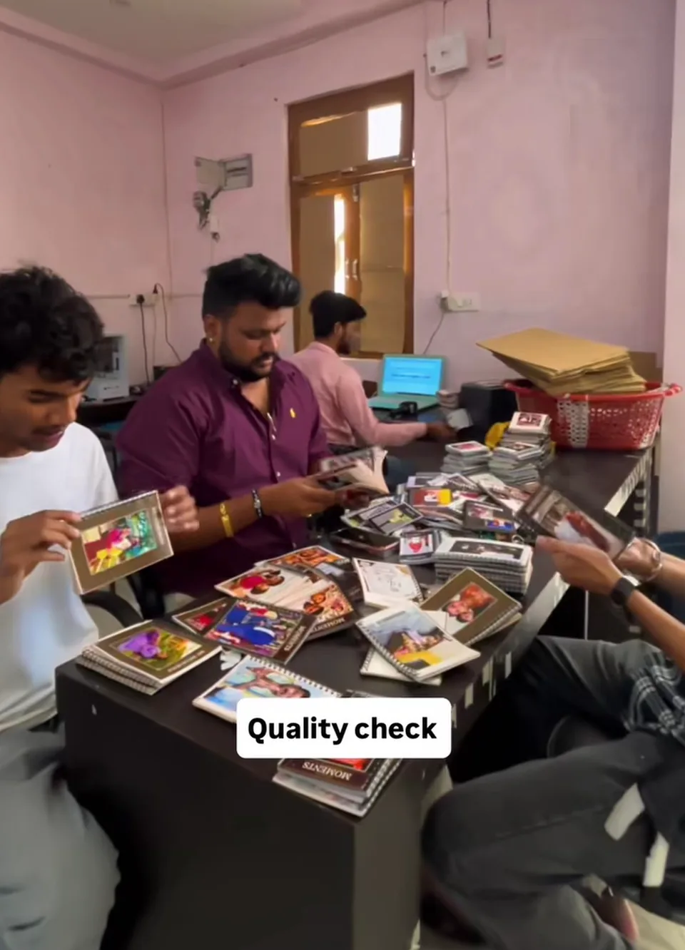 Team members examining personalised photo albums at a workbench.