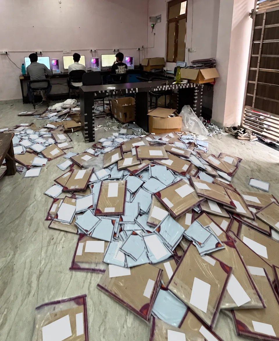 Packed parcels and packing materials across the workspace, with team members at their computers.