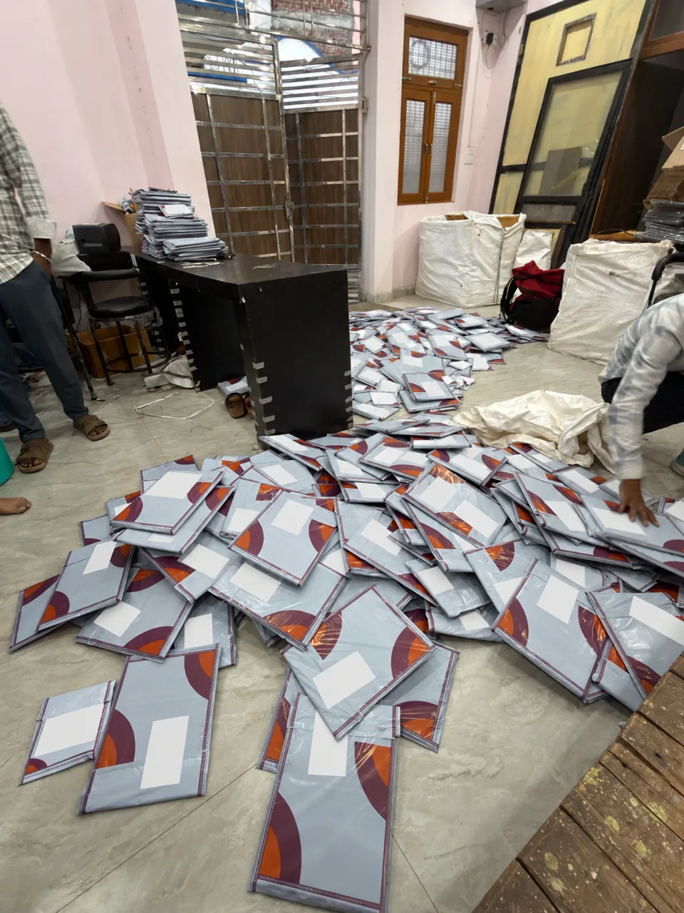 Team members handling packed parcels in the dispatch area, with sacks and parcel stacks nearby.