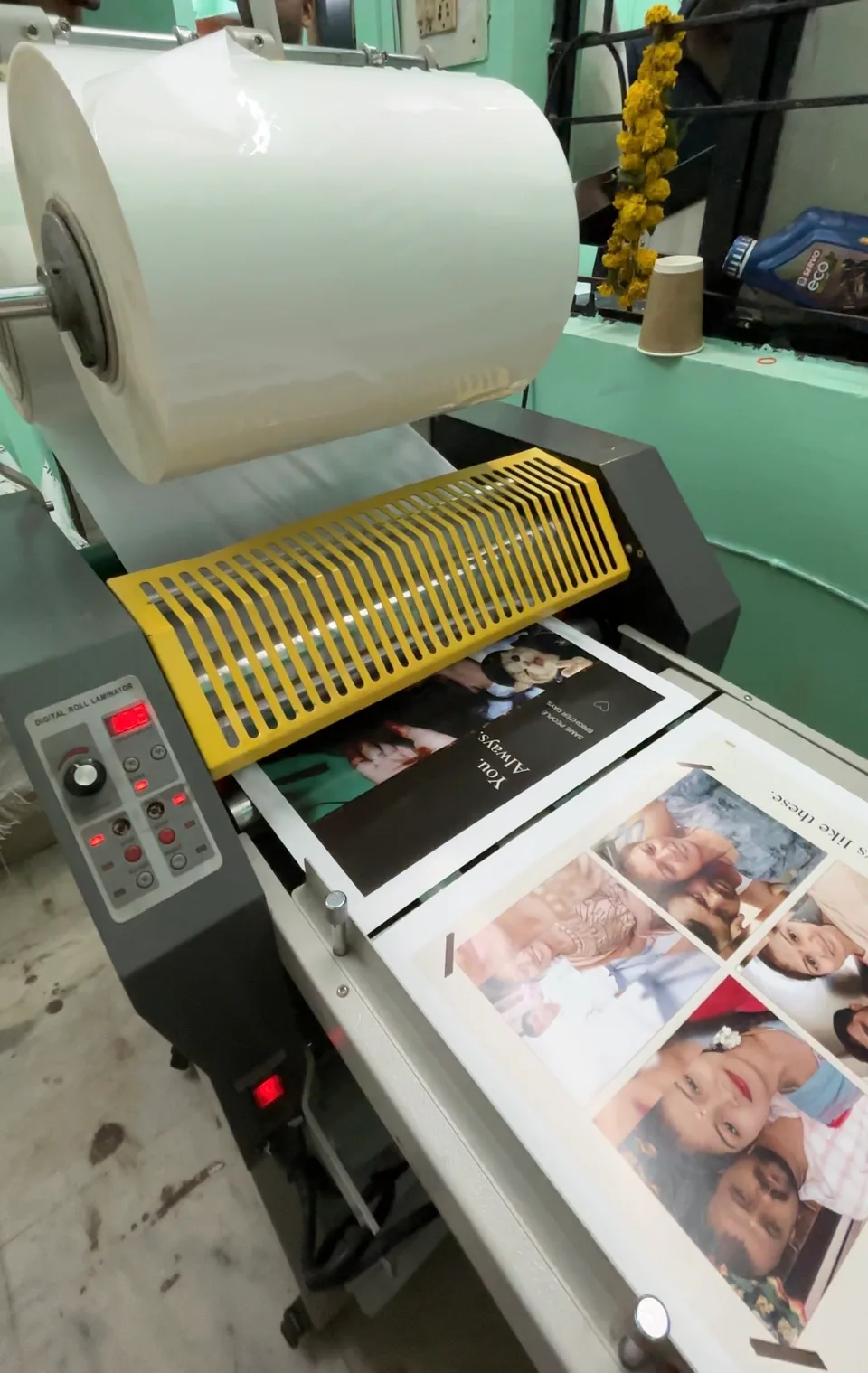 Personalised photo sheets passing through a roll laminator.
