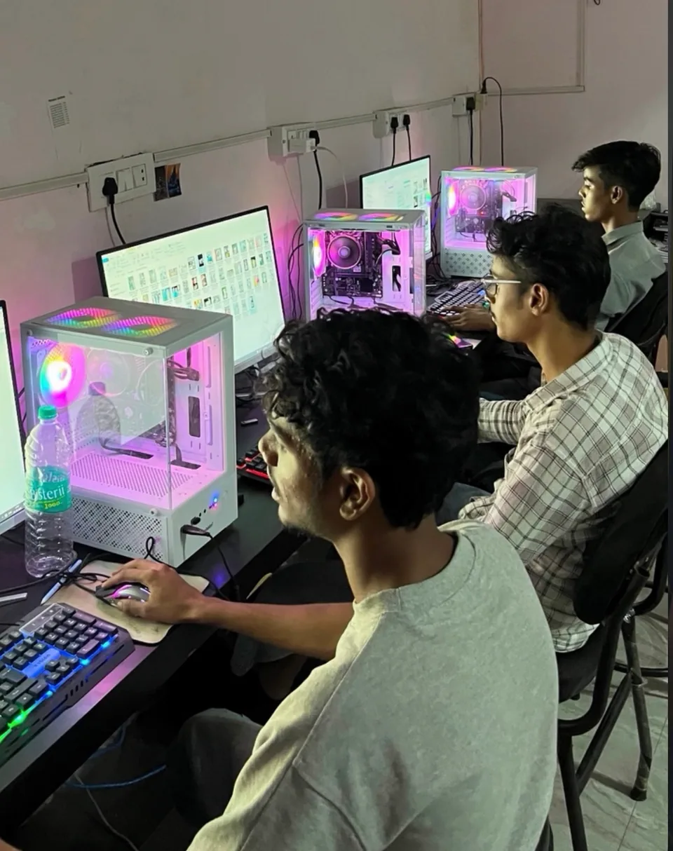 Team members working at desktop computers in the Soni Enterprises workspace.